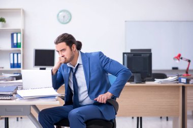 Genç bir erkek işçi aşırı işten memnun değil.