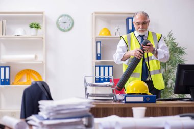 Ofiste çalışan yaşlı bir mimar.