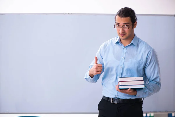 Jovem professor bonito na frente do quadro branco — Fotografia de Stock