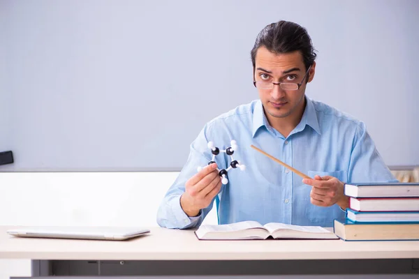 Mladý učitel fyziky mužského pohlaví před tabulí — Stock fotografie