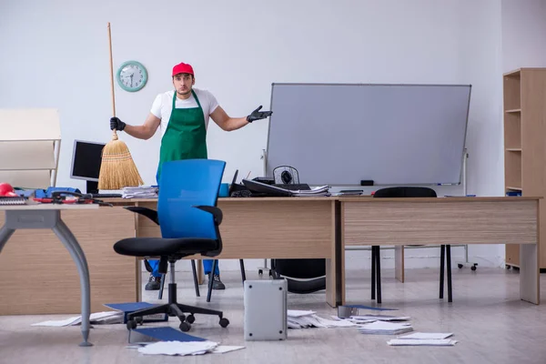 Jovem empreiteiro limpando o escritório — Fotografia de Stock