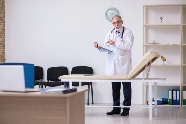 Dokter laki-laki tua bekerja di klinik — Stok Foto