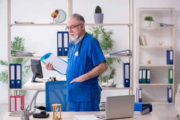 Starý lékař pracující na klinice — Stock fotografie