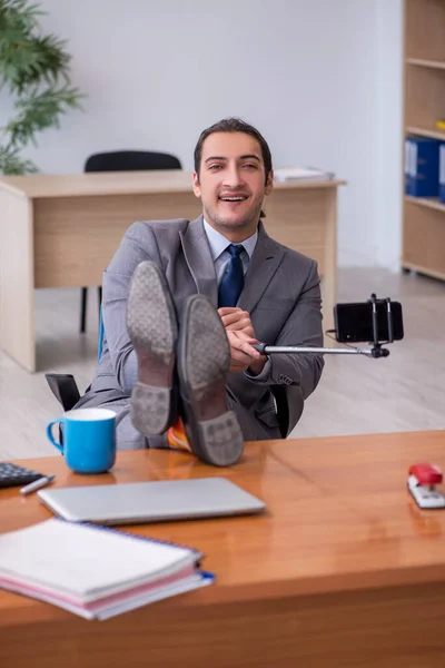 Jovem funcionário masculino com vídeo de gravação de smartphones para seu blog — Fotografia de Stock