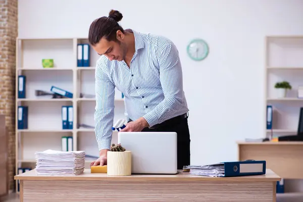 Junge männliche Angestellte putzen Büro während Pandemie — Stockfoto