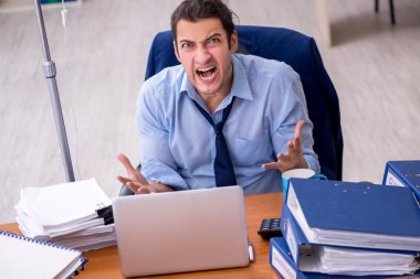 İş yerinde acı çeken genç bir erkek işçi.