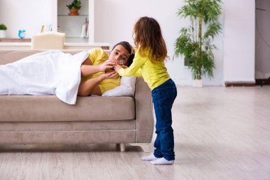 Küçük kız hasta babasına bakıyor.