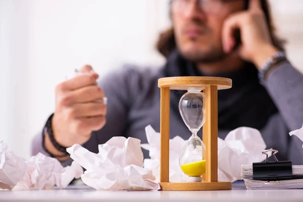 Jonge mannelijke schrijver in time management concept — Stockfoto