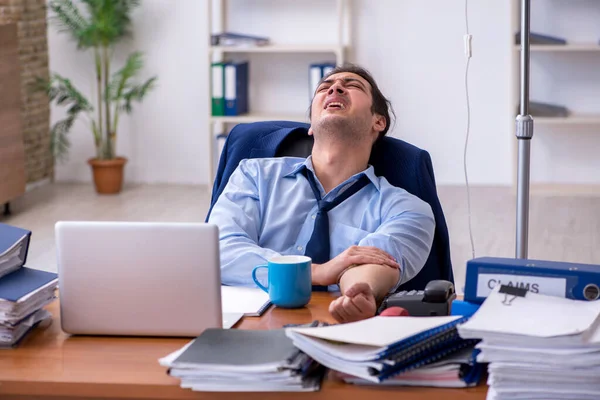 Junge männliche Mitarbeiter leiden am Arbeitsplatz — Stockfoto