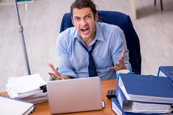 Young male employee suffering at workplace — Stock Photo, Image