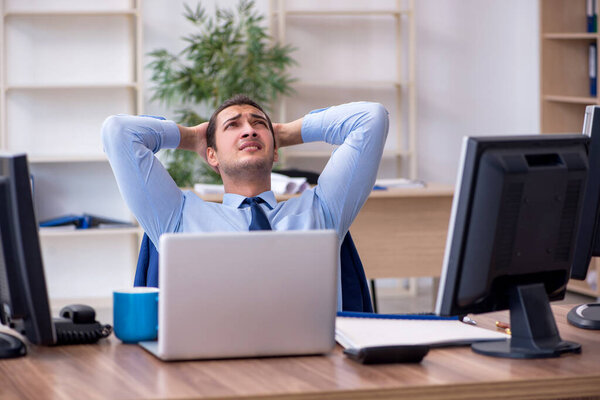 Young male employee unhappy with excessive work