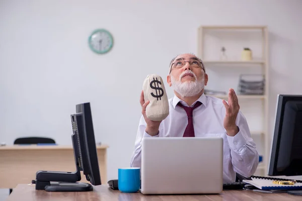 Alte männliche Chefin sitzt am Schreibtisch im Büro — Stockfoto