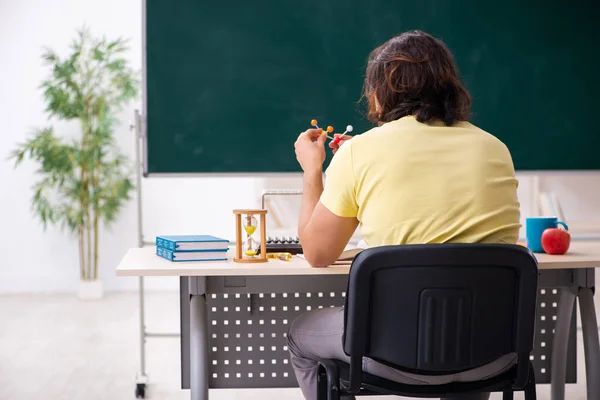 Jonge mannelijke student natuurkundige voorbereiding voor examens in de klas — Stockfoto