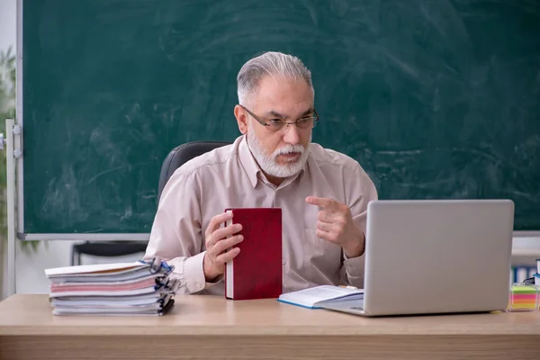 Velho professor sentado na sala de aula — Fotografia de Stock