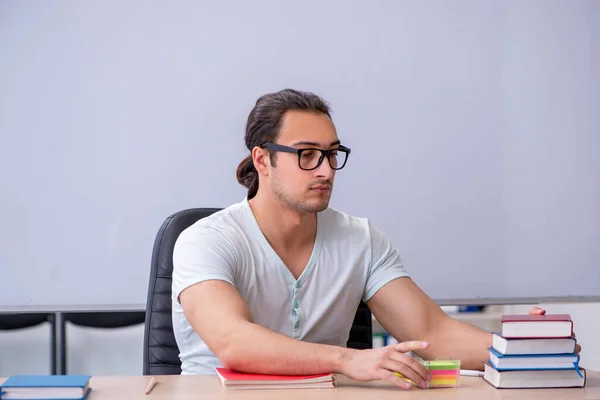 Junge männliche Lehramtsstudentin sitzt im Klassenzimmer — Stockfoto