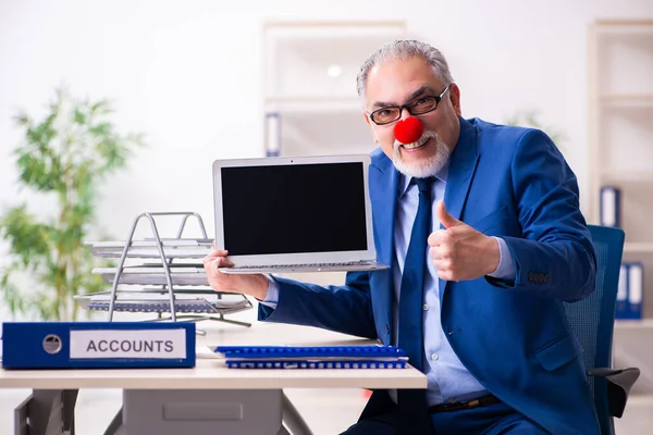 Old businessman clown working in the office