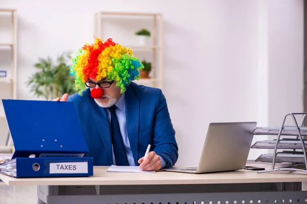 Oude zakenman clown werkt in het kantoor — Stockfoto