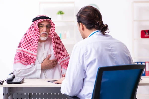 Viejo árabe masculino visitando joven médico masculino —  Fotos de Stock