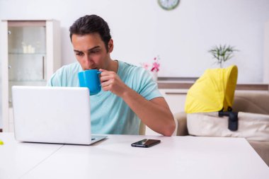 Genç erkek ebeveyn yeni doğan bebeğe evde bakıyor.