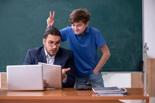 Jonge mannelijke leraar en schooljongen in de klas — Stockfoto