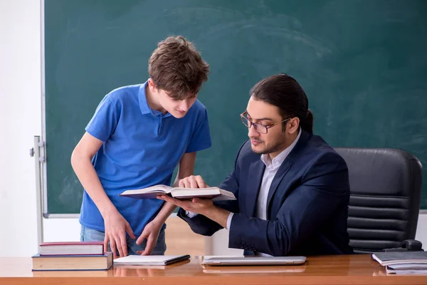 Jonge mannelijke leraar en schooljongen in de klas — Stockfoto