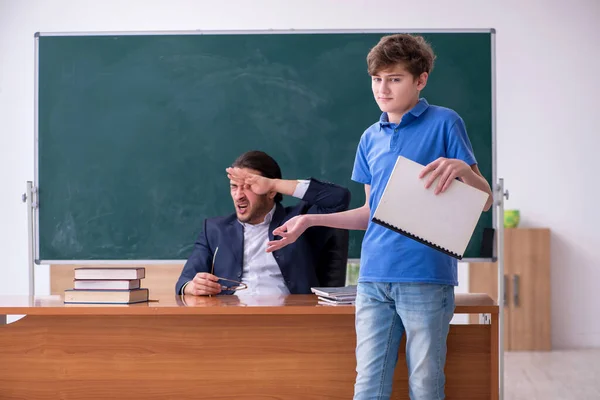 Jonge mannelijke leraar en schooljongen in de klas — Stockfoto