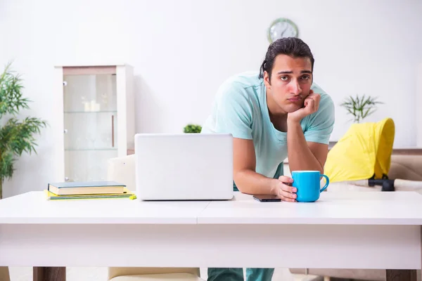 Young male parent looking after newborn at home