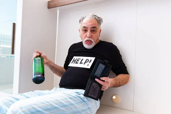 Yaşlı adam yatak odasında şarap içiyor. — Stok fotoğraf