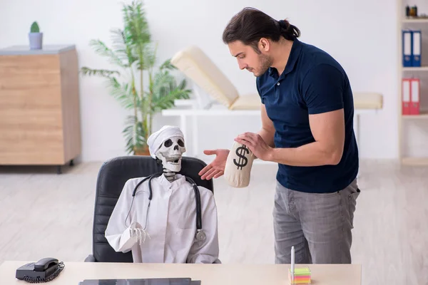 Junger Mann besucht toten Arzt in teurem Medikamentenkonzept — Stockfoto