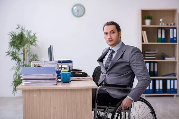 Junge männliche Auszubildende im Rollstuhl am Arbeitsplatz — Stockfoto