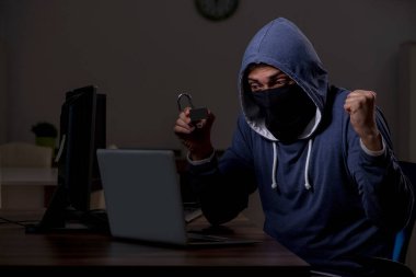 Erkek bilgisayar korsanı, güvenlik duvarını geç saatlerde hackliyor.