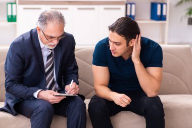 Genç adam yaşlı erkek psikoloğu ziyaret ediyor.