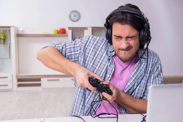 Młody mężczyzna student grać w gry komputerowe w domu — Zdjęcie stockowe