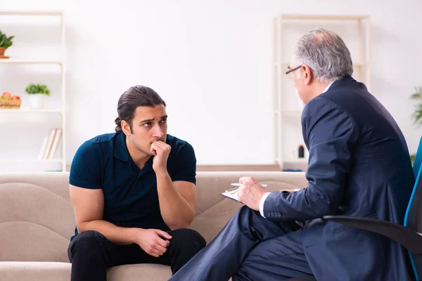 Young man visiting old male psychologist — Stock Photo, Image