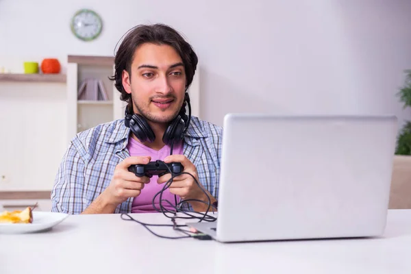 Jovem estudante do sexo masculino jogando jogos de computador em casa — Fotografia de Stock