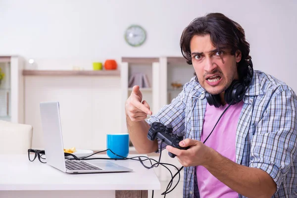 Jovem estudante do sexo masculino jogando jogos de computador em casa — Fotografia de Stock