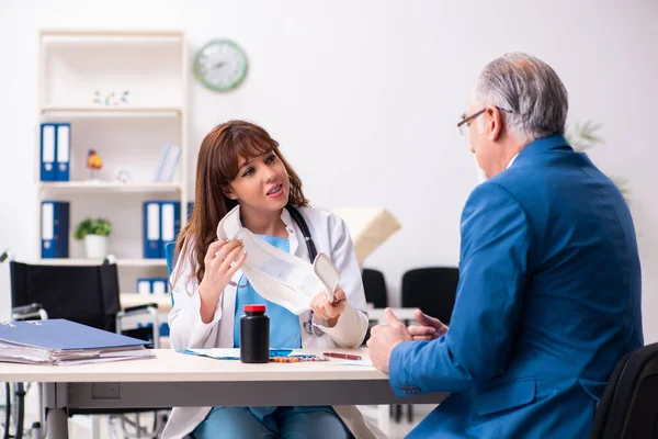 Alt unternehmer besuch jung frau doktor — Stockfoto