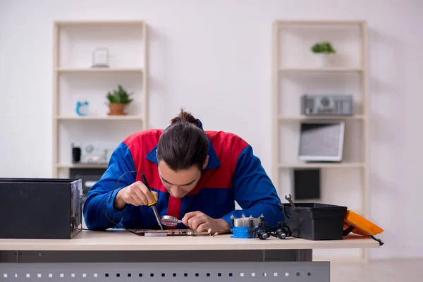 Junge männliche Reparaturarbeiter reparieren Computer — Stockfoto
