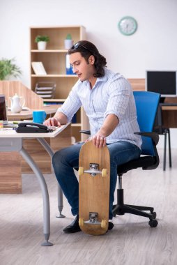 Ofiste kaykaylı genç bir erkek çalışan var.