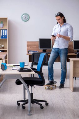 Ofiste kaykaylı genç bir erkek çalışan var.