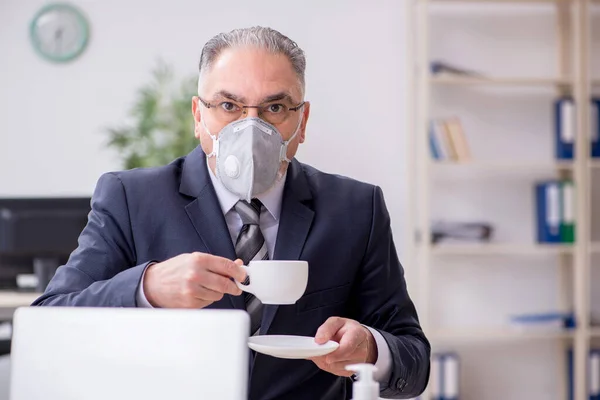 Velho funcionário chefe do sexo masculino trabalhando durante a pandemia — Fotografia de Stock