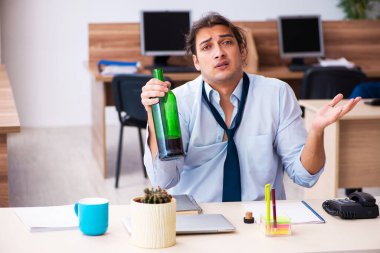 İş yerinde alkol alan genç bir erkek işçi.