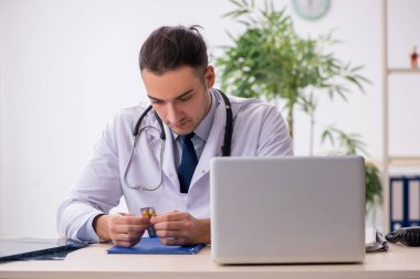 Klinikte çalışan genç erkek doktor.