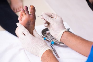 Erkek doktor travmatoloğu ziyaret eden yaralı bir kadın.