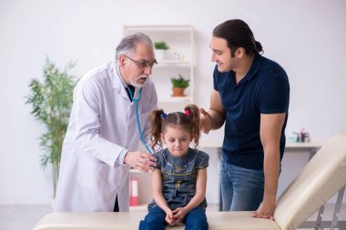 Genç baba ve kızı yaşlı doktoru ziyaret ediyor.