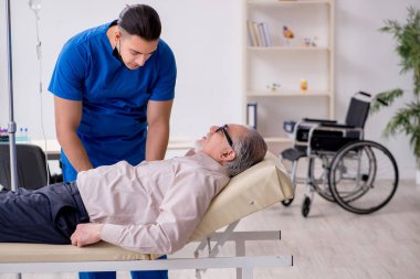 Yaşlı hasta damar içi tedavi için genç erkek doktoru ziyaret ediyor.