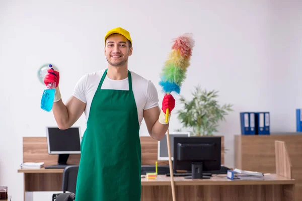 Joven contratista masculino limpiando la oficina — Foto de Stock