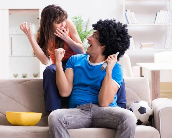 Joven hombre viendo fútbol con su esposa en casa — Foto de Stock