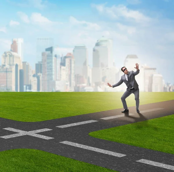 Young businessman at crossroads in uncertainty concept — Stock Photo, Image