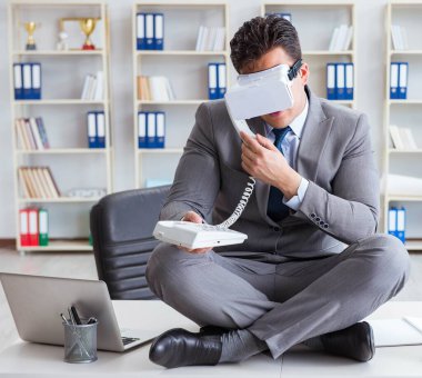 Sanal gerçeklikteki iş adamı VR gözlükleri masanın üstünde meditasyon yapıyor.